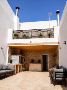 an outdoor patio with two couches and a balcony at EL CHORRO Aire acondicionado Bar privado Barbacoa Amplios patios in Castalla