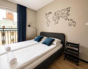 a bedroom with a large bed with a window at CudNajem Old Town Apartments - Bulvar in Elblag