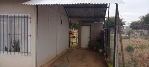 a building with a garage with a green hose at Mi Paraiso in General Pico +3 photos