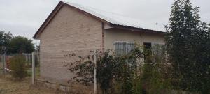 a brick house with a fence in front of it at Mi Paraiso in General Pico