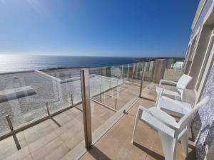 a balcony with chairs and a view of the ocean at Ocean View Apartments in Lourinhã