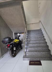 a motorcycle parked next to a staircase in a building at AP Completo Próx Centro, Hospitais, Dist Industrial in Montes Claros