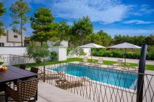 a swimming pool with a table and chairs and umbrellas at Villa Rocco in Srima