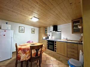 a kitchen with a table and a white refrigerator at Le Charme in Eauze