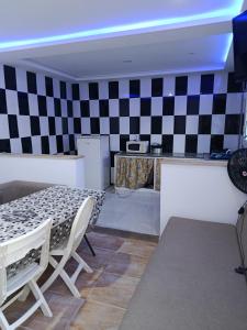 a room with a table and a checkerboard wall at Résidence de la mer in Île Pilau +14 photos