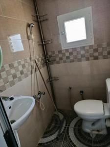 a bathroom with a toilet and a sink at Résidence de la mer in Île Pilau