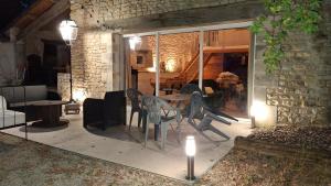 a patio with chairs and a table with lights at La grange d'Isabelle in Rouillac +2 photos