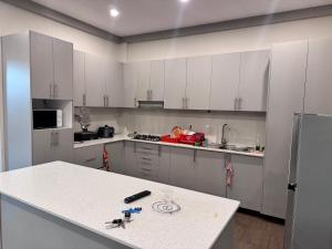a kitchen with white cabinets and a white counter top at Reddy Home in Lautoka
