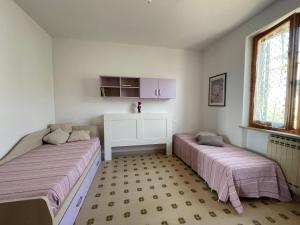 a bedroom with two beds and a window at ca' de Nardo in Tuoro sul Trasimeno