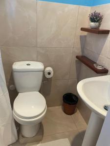 a bathroom with a white toilet and a sink at Attres in Monkey Hill