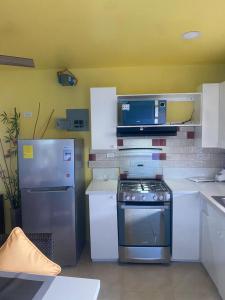 a kitchen with a stove and a refrigerator at Attres in Monkey Hill