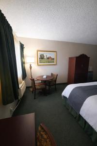 a hotel room with a bed and a table at The Jeffreys Hotel Extended Stay in Osceola