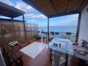 a balcony with a table and a view of the ocean at Teocle Beach rooms in Giardini Naxos