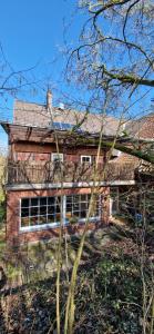 a brick house with a balcony on the side of it at Dehmkerhof in Aerzen