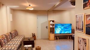 a living room with a couch and a flat screen tv at Imsouane Harmony in Imsouane