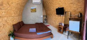 a bedroom with a bed and a tv in a room at ลุงพล โฮมสเตย์ เชียงดาว in Chiang Dao