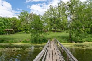 a wooden bridge over a pond in a park at The Jeffreys Hotel Extended Stay in Osceola