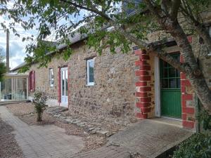a brick house with a green door on the side of it at Domaine de la Viloudard in Saint-Aignan
