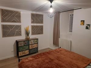 a bedroom with a large bed and a dresser in it at Domaine de la Viloudard in Saint-Aignan
