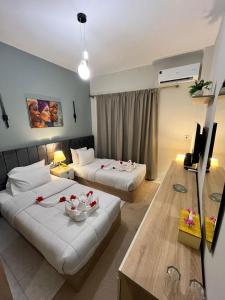 a hotel room with two beds and a television at SEACODE Hotel in El Alamein +37 photos