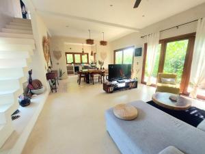 a living room with a couch and a tv at Private luxury villa in Holbox Island