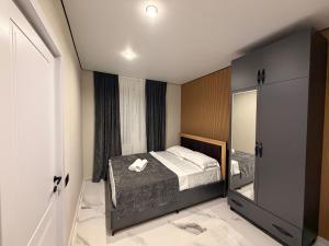 a small bedroom with a bed and a mirror at Tornikes Cottages in Ureki