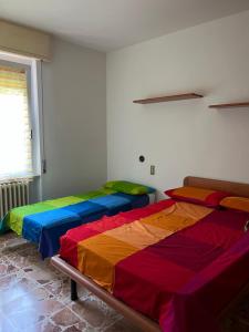 two beds in a room with colorful sheets at Casa Antonio in Riva di Solto