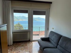 a living room with a couch and a view of the ocean at Casa Antonio in Riva di Solto
