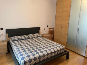 a bedroom with a bed with a blue and white comforter at Casa Antonio in Riva di Solto