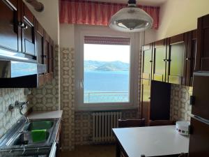 a kitchen with a window with a view of the ocean at Casa Antonio in Riva di Solto