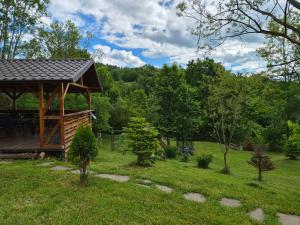 a wooden gazebo in a field with trees at Forest House Doftana in Teşila