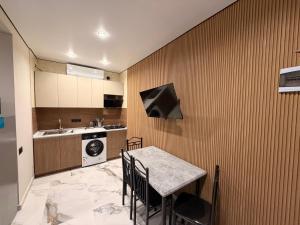 a kitchen with a table and a sink and a stove at Tornikes Cottages in Ureki