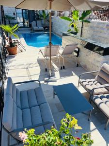 a patio with chairs and a table and an umbrella at The Poet's House in Himare