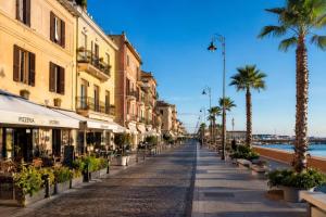 an empty street with palm trees and buildings at Seven Suite SPA in Fiumicino