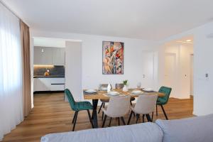 a dining room and living room with a table and chairs at Villa Rocco in Srima