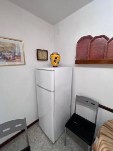 a white refrigerator in a room with a clock and a chair at Eclipse in Villasandino