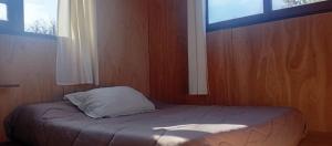a bed with a pillow in a room with a window at Casa en Marindia Sur in Salinas