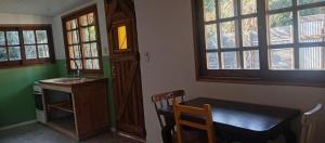 a room with a table and a chair and windows at Casa en Marindia Sur in Salinas