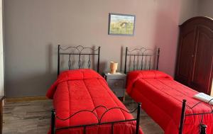 two beds with red covers in a room at Antico Borgo in Tarsia