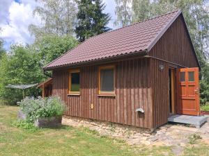 a small wooden cabin with a brown roof at Ádova chatová osada in Úbislav +17 photos