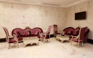 a living room with red leather couches and chairs at فندق برج السيف in Mecca +28 photos