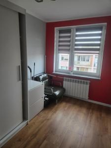 a living room with a black leather couch and a window at Apartament Słobódka in Słobódka