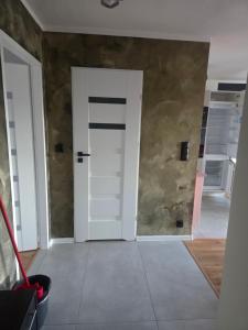 a room with a white door and a wall at Apartament Słobódka in Słobódka