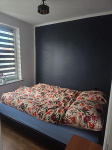 a bedroom with a bed with a colorful comforter at Apartament Słobódka in Słobódka