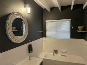 a bathroom with a tub and a sink and a mirror at Happy Place in Grotto Bay +5 photos