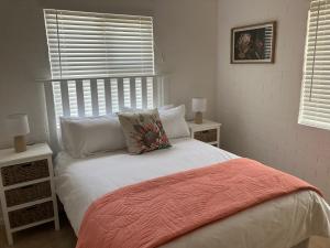 a bedroom with a bed with white sheets and pillows at Happy Place in Grotto Bay