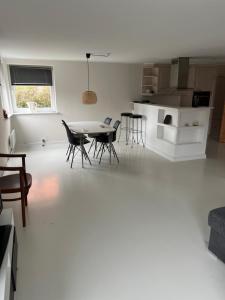 a white living room with a table and chairs at Hus i to plan i Nakskov by in Nakskov