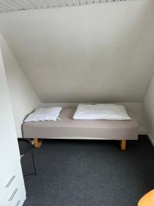 a bed in a room with two white pillows at Hus i to plan i Nakskov by in Nakskov