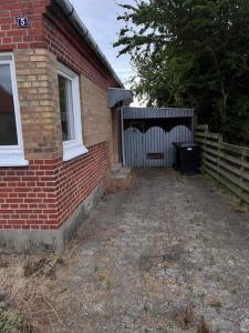 a brick house with a gate and a fence at Hus i to plan i Nakskov by in Nakskov