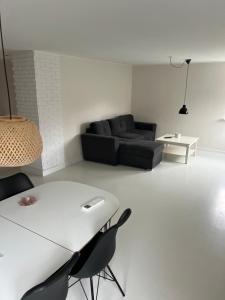 a living room with a couch and a table at Hus i to plan i Nakskov by in Nakskov